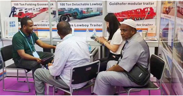 Clientes nigerianos visitan el stand de TITAN en la Feria de Cantón para comprar un remolque de cuello de cisne plegable.