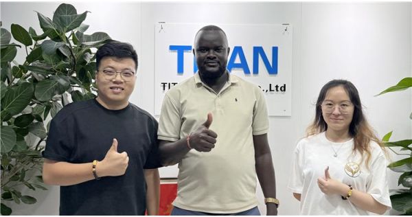 Un cliente de Tanzania visita TITAN para comprar un remolque de plataforma baja con cuello de cisne de ancho completo.