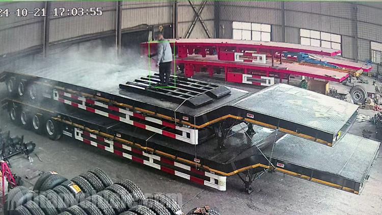 Los trabajadores están rociando cera en estos remolques de baja carga.